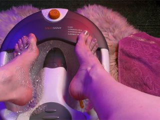 Молодая фемба моет свои гладкие ноги в ванне для массажа и мажет их кремом